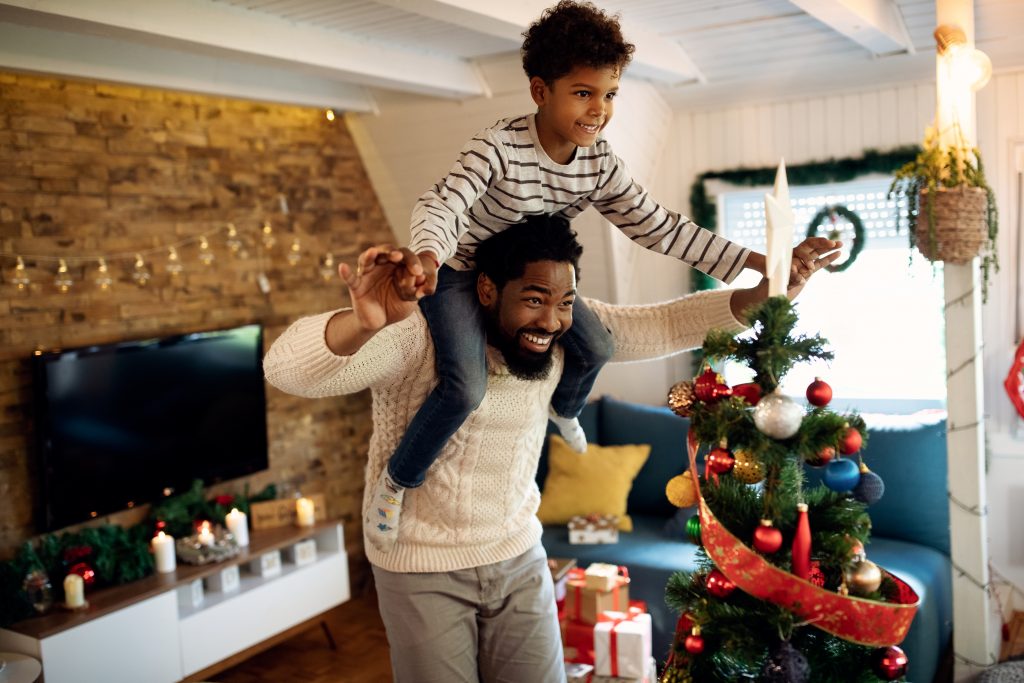 Dad engaging in fun Christmas activities with son