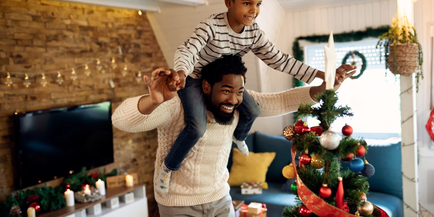 Dad engaging in fun Christmas activities with son