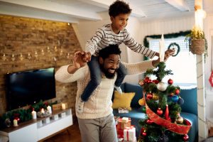 Dad engaging in fun Christmas activities with son